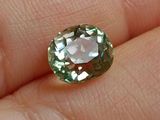 un gros plan sur la main d'une personne tenant un diamant vert et blanc