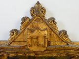 un cadre doré surmonté d'une horloge