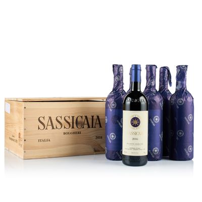 trois bouteilles de vin devant une caisse en bois contenant du vin