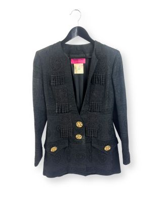 La veste est noire, avec des boutons dorés sur le devant.