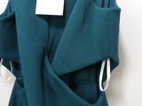 a green dress hanging on a hanger with a tag on it