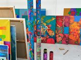 une pièce remplie de matériel artistique et de tableaux accrochés aux murs