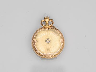 a gold pocket watch with a diamond in the center