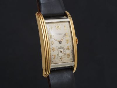 une image d'une montre-bracelet plaquée or avec un bracelet en cuir noir