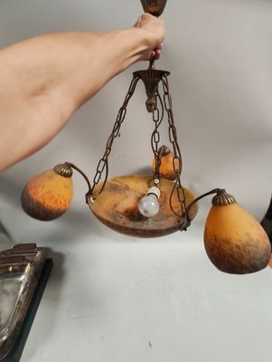 a person that is holding a light that is hanging from a chandelier