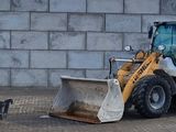 une photo d'un engin de chantier garé devant un mur de briques