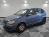 La voiture bleue est garée sur le sol à damier du garage.