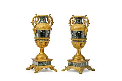pair of gold and marble vases on pedestals on a white background
