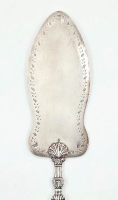 une cuillère en argent avec un manche sur une surface blanche