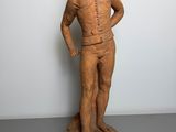 an old wooden statue of a man with a hat on his head