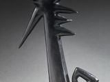 a black sculpture of a person holding a bird on top of a table