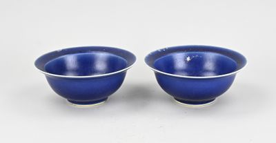 a pair of blue bowls sitting on top of a white table