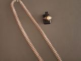collier et bracelet ornés d'une croix sur fond gris