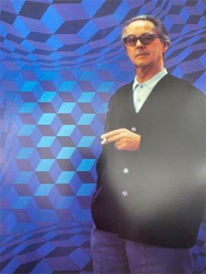 an image of a man standing in front of a blue and black checkered background