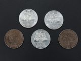 four different types of coins sitting on top of a black surface