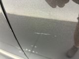 a reflection of a person standing on a car door