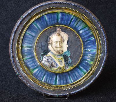 une photo d'une assiette bleue et dorée sur laquelle figure l'image d'un homme