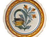 a plate with a bird on it and a flower in the middle