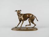 bronze statue of a dog running on a base with a ball