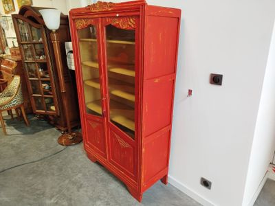 une armoire rouge avec une porte vitrée dans une pièce