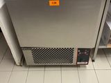 une photo d'un réfrigérateur dans une cuisine, avec un panier posé dessus