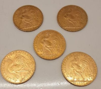 quatre souverains d'or, dont l'un est orné d'une tête de lion, sont représentés sur un fond blanc