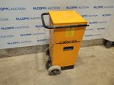 a yellow cart sitting in front of a wall with a sign on it