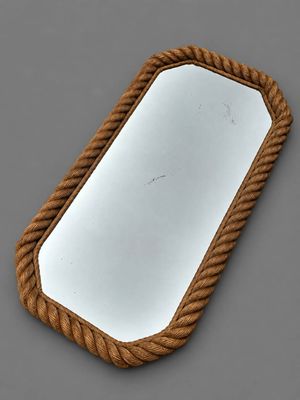 miroir dont le pourtour est entouré d'une corde, posé sur une surface grise