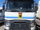 un camion blanc orné d'une bande bleue, garé sur un parking