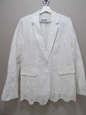 the white jacket is hanging on a hanger on the wall