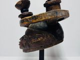 a close up of a wooden sculpture on a black stand