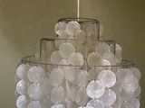 a chandelier made out of plastic discs hanging from a ceiling