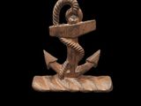 un gros plan sur une statue représentant une ancre posée sur un socle en bois