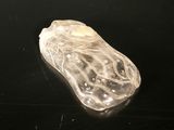 un objet en verre transparent posé sur une surface noire
