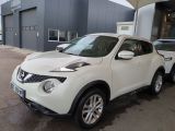 Le SUV Nissan Juke blanc est garé devant un immeuble.