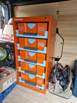 a small orange cabinet with many drawers in the back of it