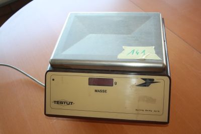 a close up of a scale on a wooden table