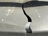 a broken piece of a trash can sitting on the side of the road