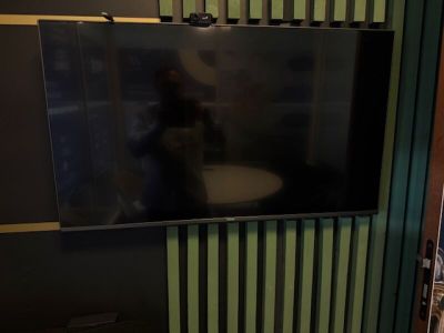 a flat screen tv mounted on a wall in a bathroom
