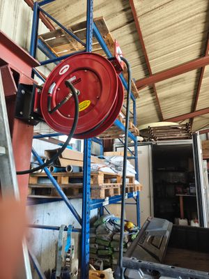 une borne d'incendie rouge posée sur un échafaudage bleu dans un entrepôt