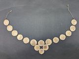a gold necklace with five discs on a chain