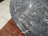 a black marble table with a red rug on the floor