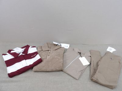 quatre paires de vêtements pour homme disposées sur un lit
