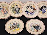 six plates with different designs on them on a black surface