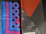 two different colored handkerchiefs on a table with a black background