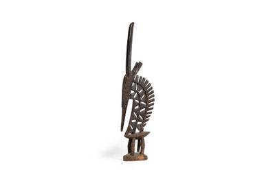 an image of a wooden sculpture of a bird and a bird on a branch