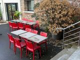many red chairs and tables outside of a restaurant