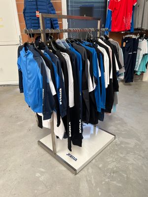 beaucoup de vêtements suspendus à une étagère dans un magasin