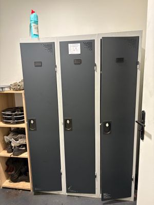 three lockers in a room with shoes on the floor