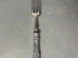 a silver fork and a silver spoon on a table